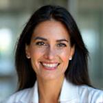 Headshot of Dr. Anaya Sharma, a smiling woman with professional yet warm demeanor, in a clinic setting.